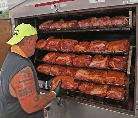 Loading pork butts in a smoker for Operation BBQ Relief