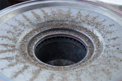 Metal disc with cup in the middle. Ashes radiate from the cup around the disc.