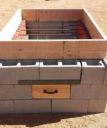 concrete block hog pit with rebar and scalloped garden edging
