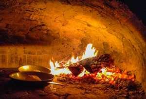 wood fire inside a domed pizza oven