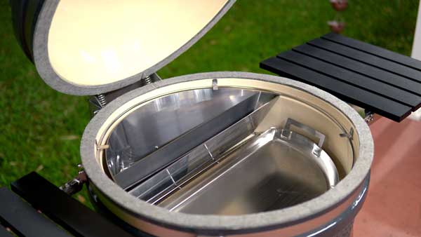 Large round bowl with open lid attached on a hinge. Shiny steel objects inserted inside the bowl.